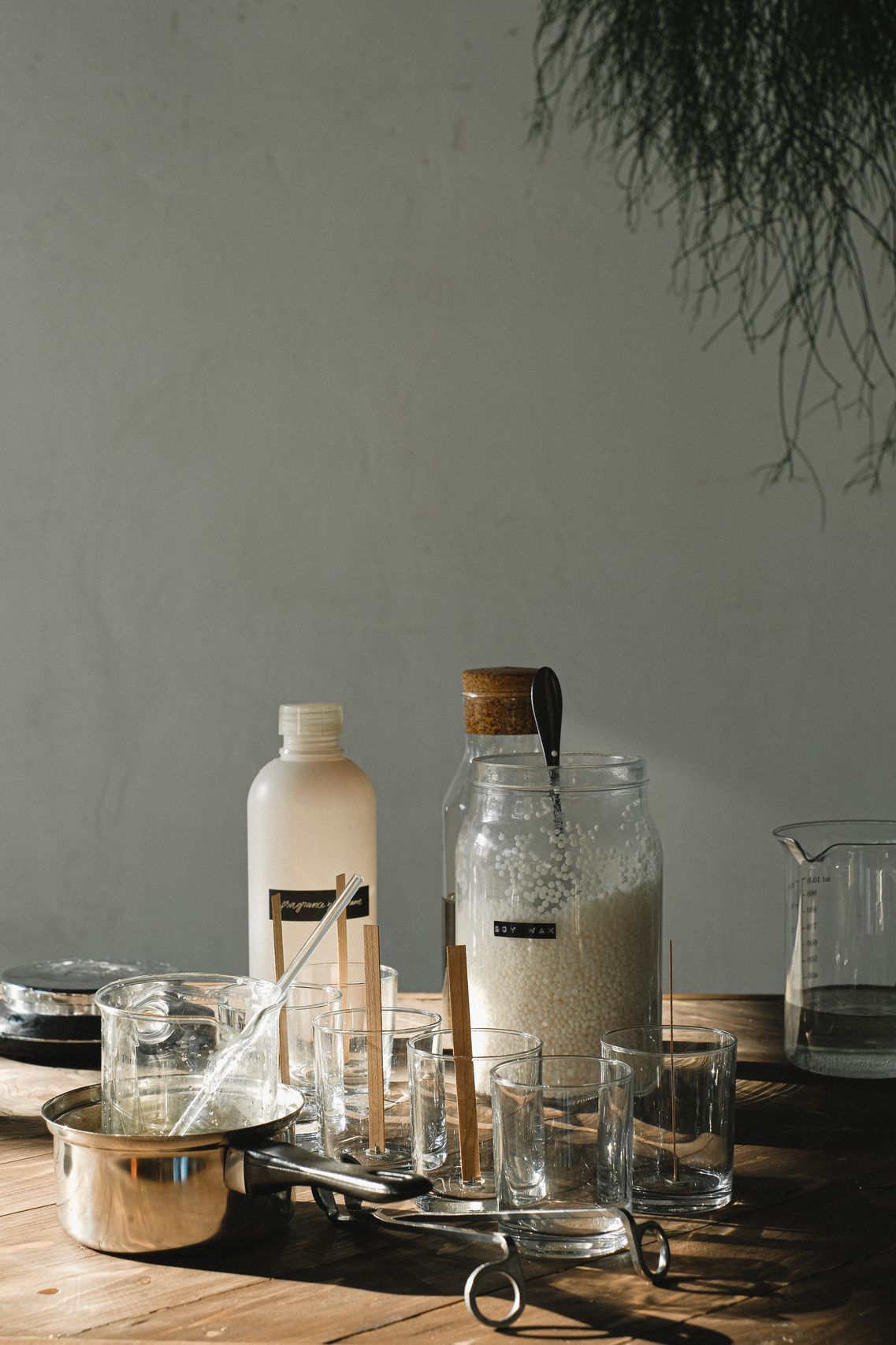 Finished artisanal soy candles in amber jars on a wooden table
