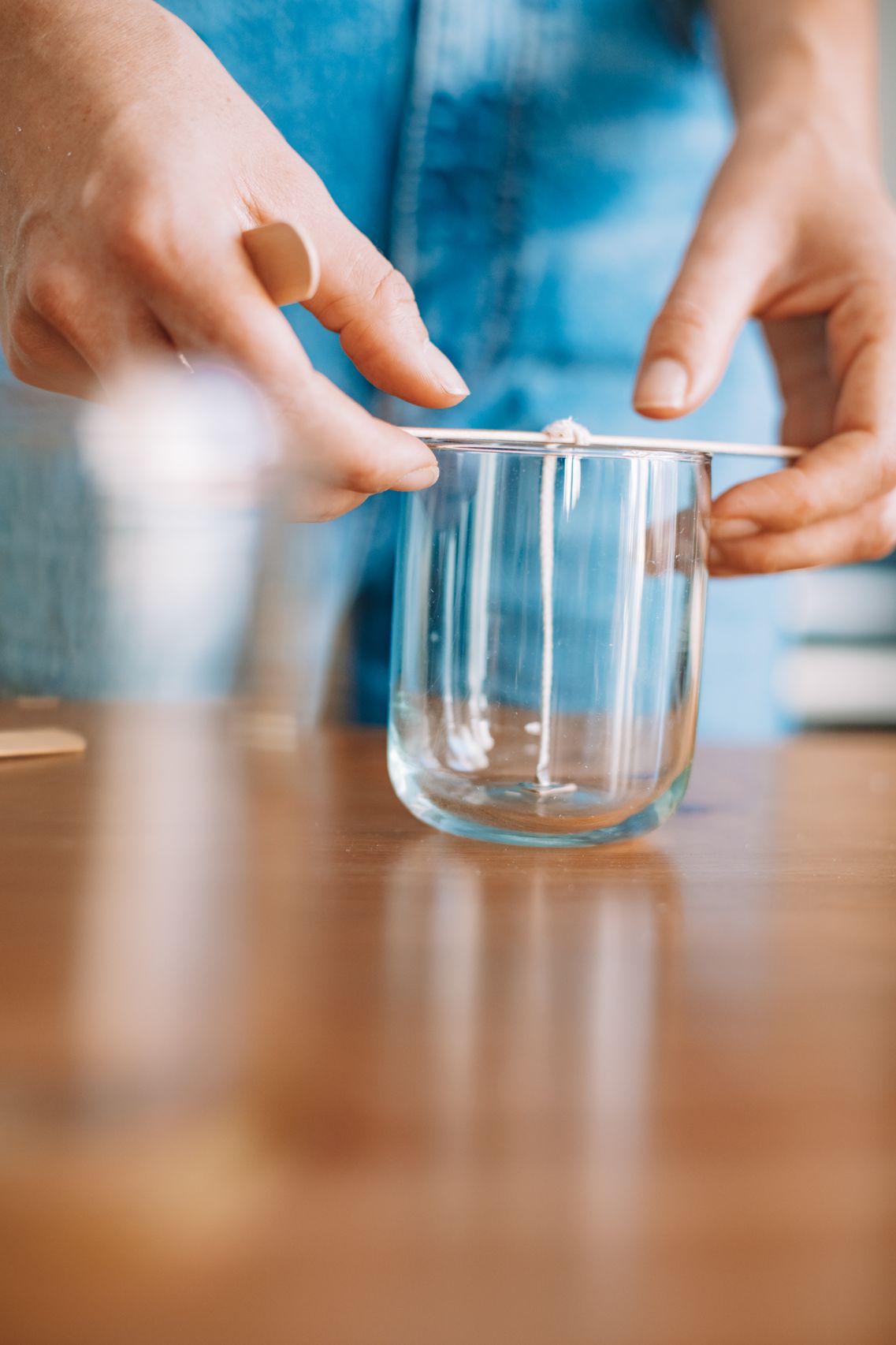 Woman carefully pouring scented wax into a glass jar